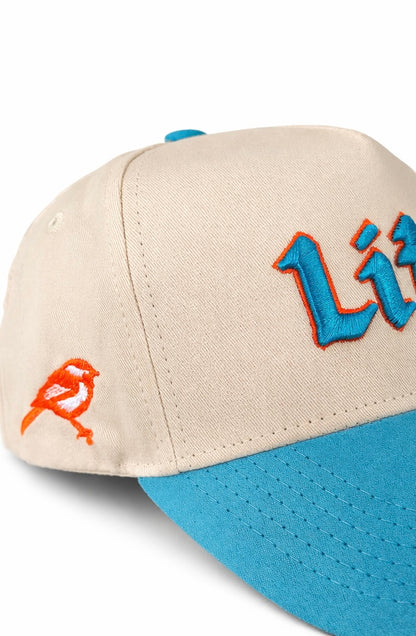Beige and blue cap with orange bird design and 'Life' text on a white background